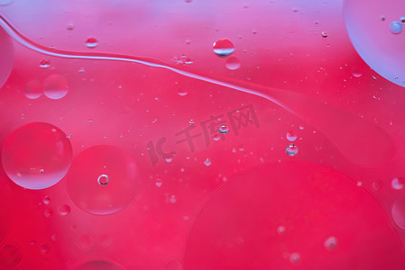 用油、水和肥皂制成的红色抽象背景图片