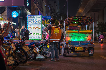肥嘟嘟的摄影照片_帕蓬夜市，人行道上有嘟嘟车出租车