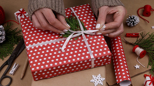 用红纸包装圣诞礼物的女人