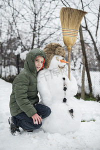 下雪院子里摄影照片_雪人和孩子在院子里