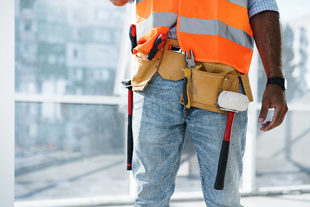 建筑工地上穿着工作服的无法辨认的男工头的特写