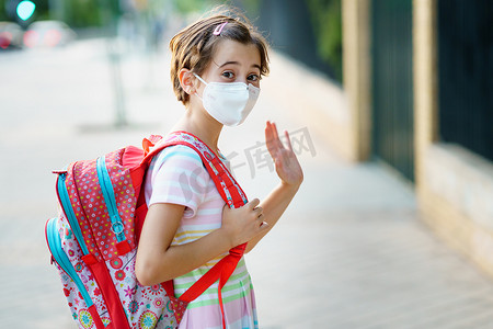 九岁女孩戴着口罩、背着书包回到学校。