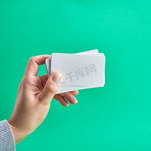 绿色背景中女性手中的白皮书名片