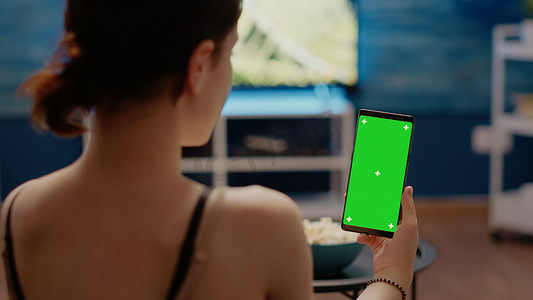 智能手机上有垂直绿屏显示的年轻人