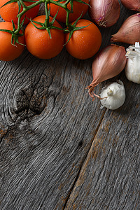 质朴的木质餐桌上的西红柿、洋葱和大蒜