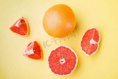 质感黄色背景摄影照片_葡萄柚柑橘类水果，一半，黄色质感夏季背景，顶视图平躺