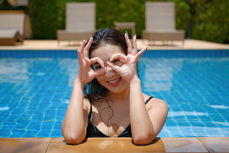 美丽的东南亚女人在泳池放松。
