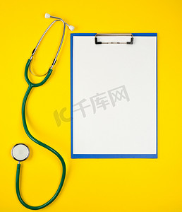 黄色背景上空的白床单和医用听诊器