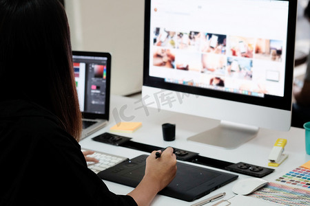 create摄影照片_使用 create gr 在创意办公室工作的平面设计师女性