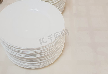 桌子上一堆白色干净的空盘子，在酒店咖啡厅提供服务