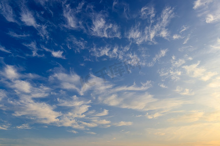 明亮的蓝色天空与羽毛云被白天的阳光照亮。