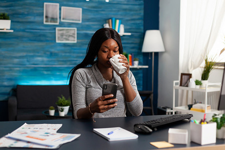 黑人妇女手持智能手机与浏览通信信息的人聊天