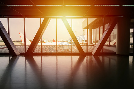 从机场航站楼之间的人行道桥看飞机停在门口的灯光效果、旅游背景和度假概念