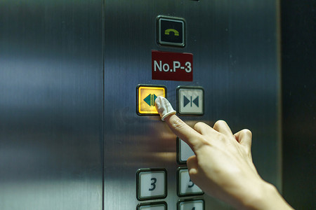 戴橡胶手指按电梯按钮的女人