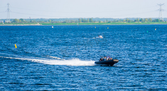 人们乘坐快艇在 oosterschelde of tholen、旅游水上运动和交通、荷兰泽兰的热门城市航行