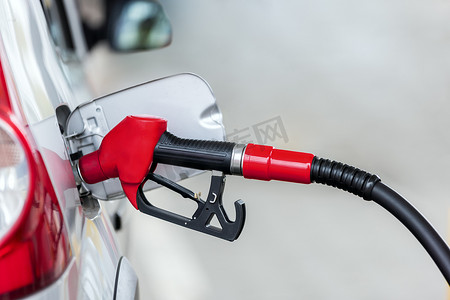 银色汽车在加油站加油，燃料能源的概念
