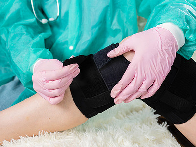 物理治疗师在受伤的膝关节上放置矫形器
