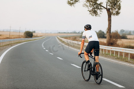 活跃男子在新鲜空气中骑自行车的后视图