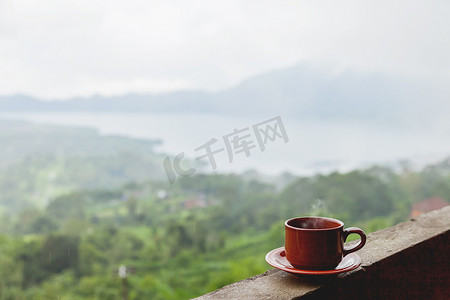 陶制杯子盛着热咖啡，立在阳台的栏杆上。