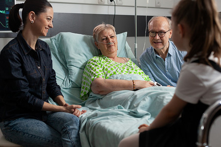 快乐的家庭支持生病的祖母去医院病房探望她