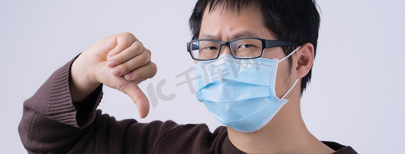 亚洲年轻男子的肖像，戴着白色背景隔离的医用外科蓝色面罩，对冠状病毒感染说不，特写，特写。