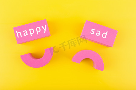 黄色背景上彼此相邻的不快乐和快乐的微笑符号。