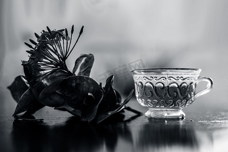 在玻璃杯中关闭木质表面的红色五角花或埃及星花或茉莉及其提取的有益解毒茶。