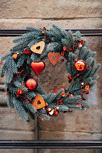 冷杉树枝的圣诞花环，石墙上有红色圣诞装饰。
