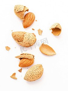 背景优势摄影照片_关闭一组杏仁坚果与壳和破裂的杏仁壳隔离在白色背景。