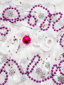 圣诞节和新年背景与数字 2019，紫罗兰装饰和灯泡。