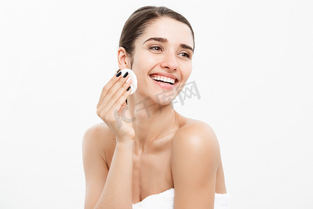 签手摄影照片_美容护肤概念-美丽的女人用棉签清洁她的脸-在白色背景和微笑。