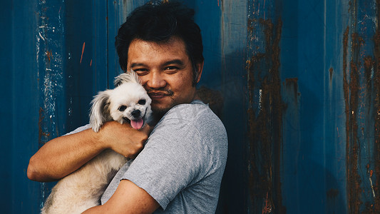 美男摄影照片_亚洲男人和狗开心地拥抱容器