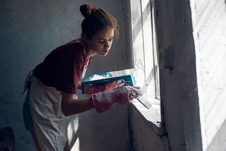 女画家用刷子油漆窗户翻新室内装饰