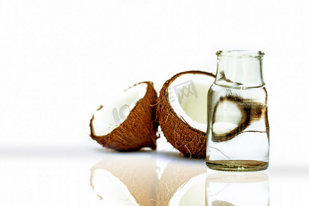 生有机切干椰子连同水一起放在一个透明玻璃瓶中，用白色隔开，并带有反射。