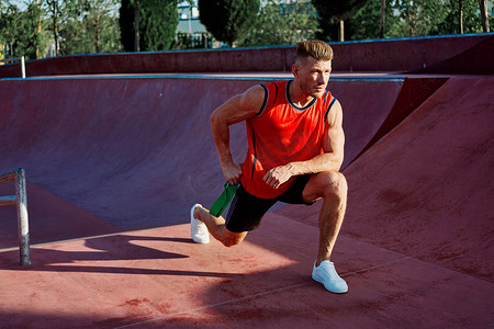 公园锻炼身体摄影照片_穿着红色球衣锻炼的健壮男子锻炼身体
