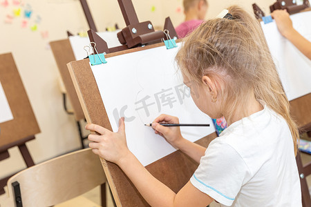 孩子们在教室的画架上画画