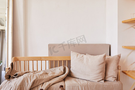 舒适的沙发，配有垫子和毯子，靠在白墙上