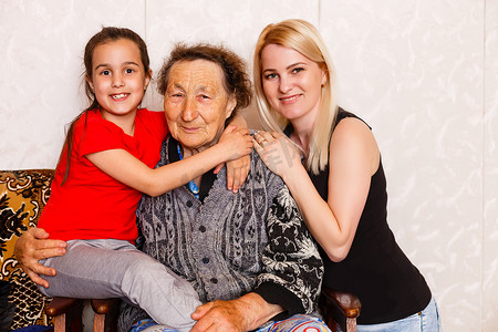 老妇人坐在家里的沙发上拥抱孙女