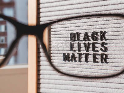 lives摄影照片_通过 eyegla 在写有 Black Lives Matter 字样的信板上查看