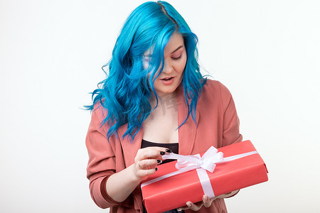 时尚礼盒摄影照片_人、时尚和假日概念 — 蓝发美女站在白色背景的礼盒上