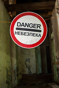 失事的旧房子，上面有英语和乌克兰语的“危险”警告标志，废弃的建筑，不适宜居住的地方
