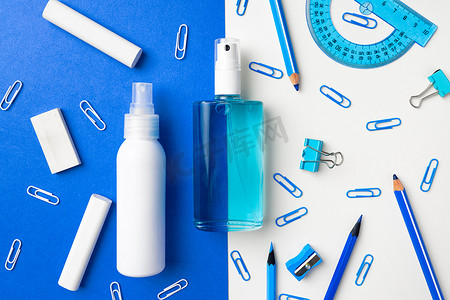 洗手液和学校用品，如粉笔、蓝白纸背景上的回形针