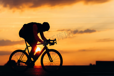 剪影中活跃的男子在新鲜空气中骑自行车