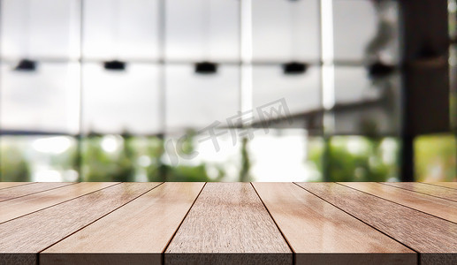 模糊餐厅背景上带灯光散景的空木桌