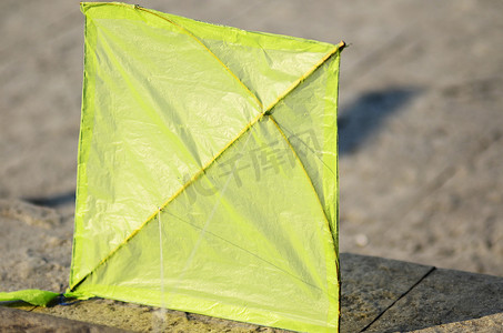 风筝玩具摄影照片_在水泥地板上的绿色风筝
