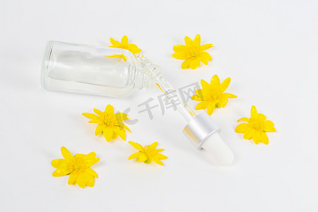 黄色春花中白色背景上装有吸管血清的瓶子