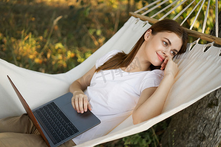 带笔记本电脑的女人躺在吊床上自由旅行
