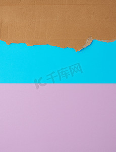 蓝紫色 backgr 上瓦楞纸板纸的撕裂边缘
