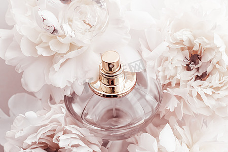 香水广告摄影照片_香水瓶作为牡丹花背景下的豪华香水产品、香水广告和美容品牌