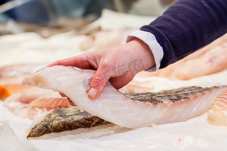 方型剪纸摄影照片_鱼贩在市场上拿着一条鲜鱼